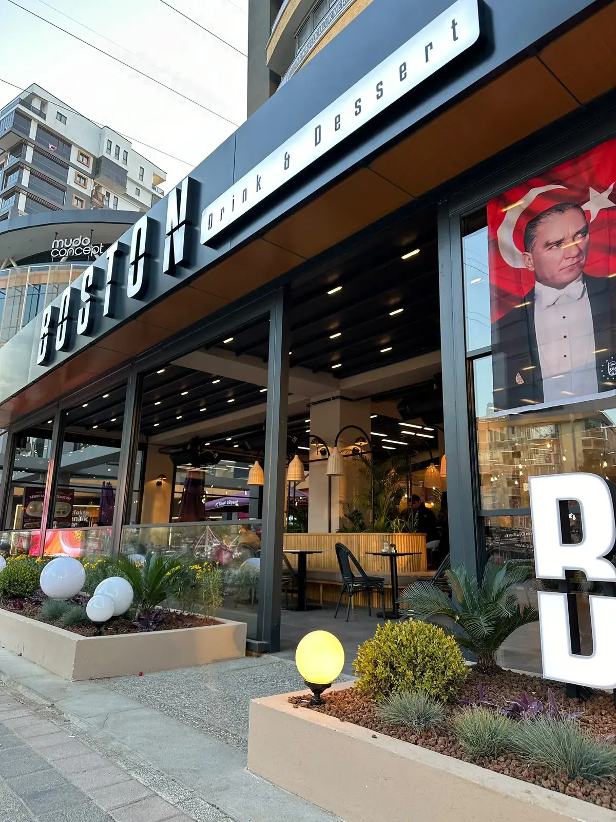 Bistro önünde antrasit profilli pergola tente ile kapatılmış oturma alanı