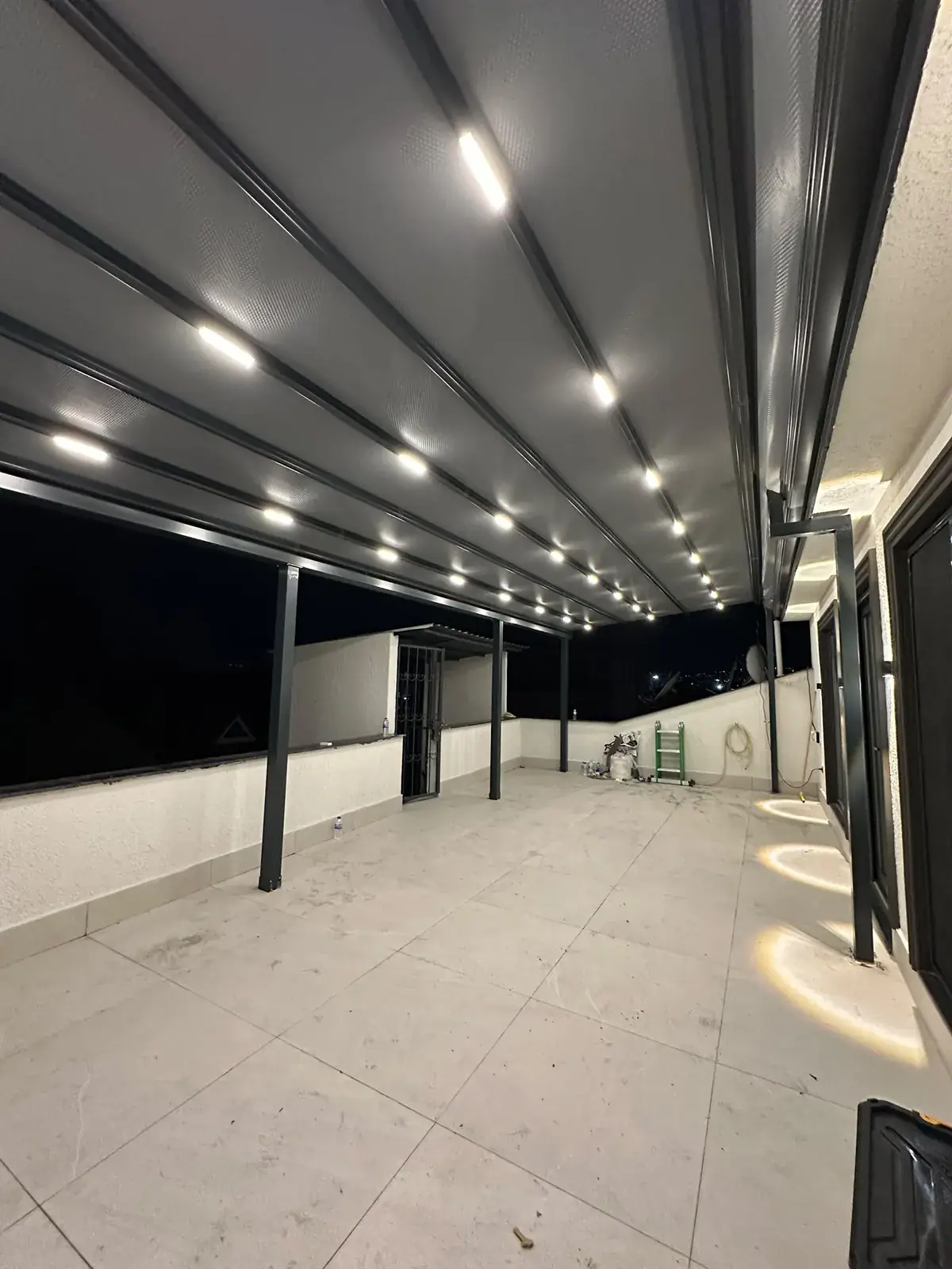 Geniş çatı terasında boydan boya pergola tente ve LED aydınlatma