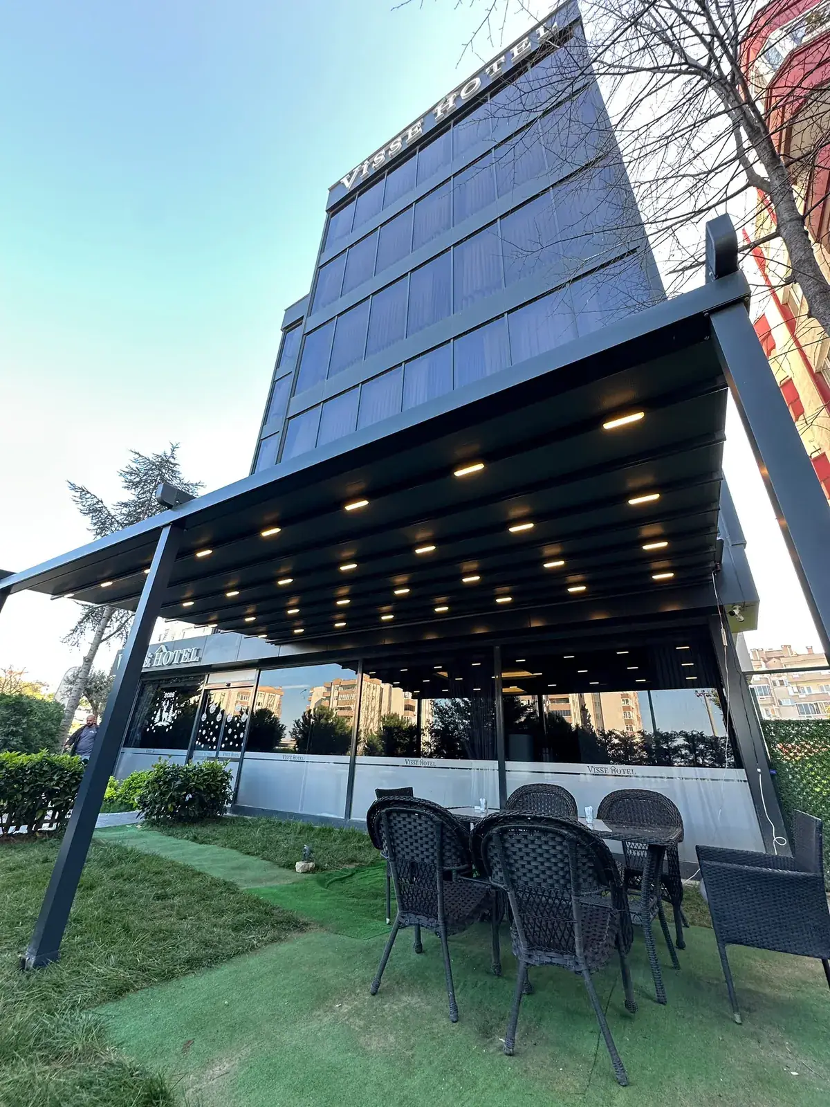 Ofis binasının bahçesinde oturma alanı için kurulan pergola tente