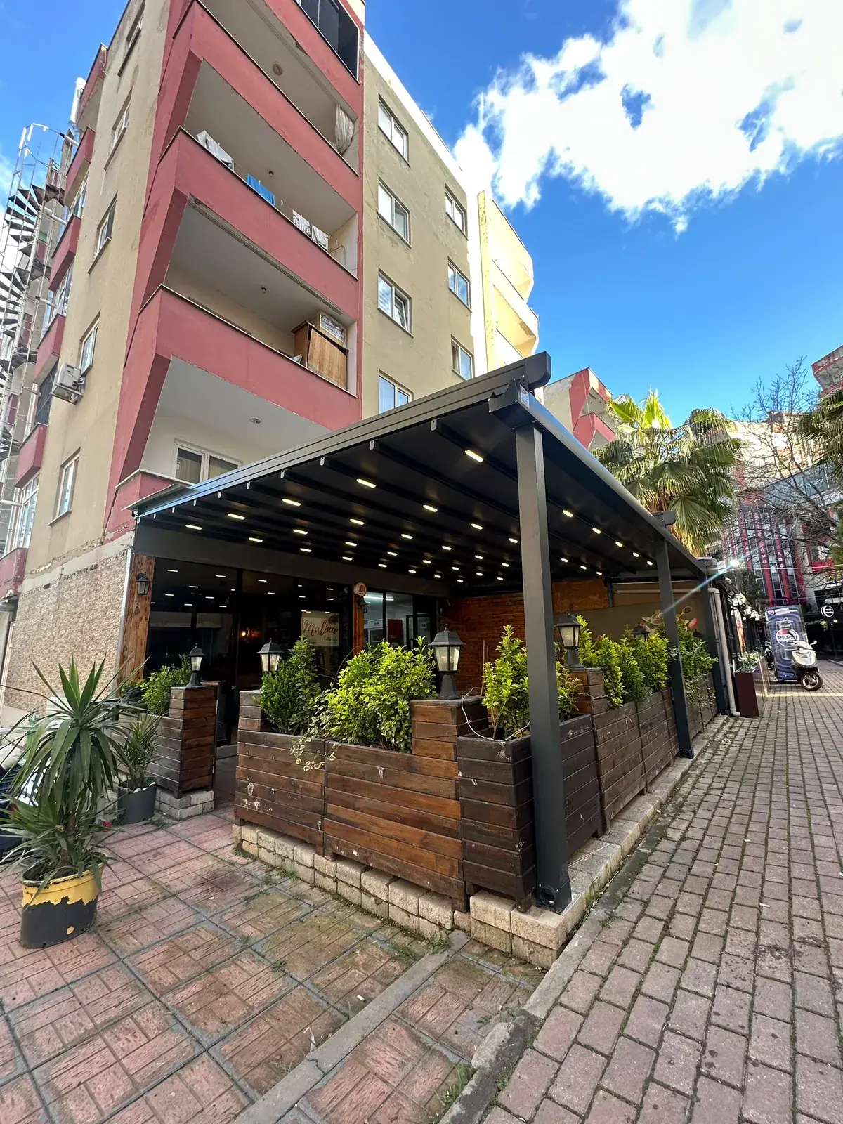 Bina önündeki restoran terasına kurulan LED aydınlatmalı pergola tente