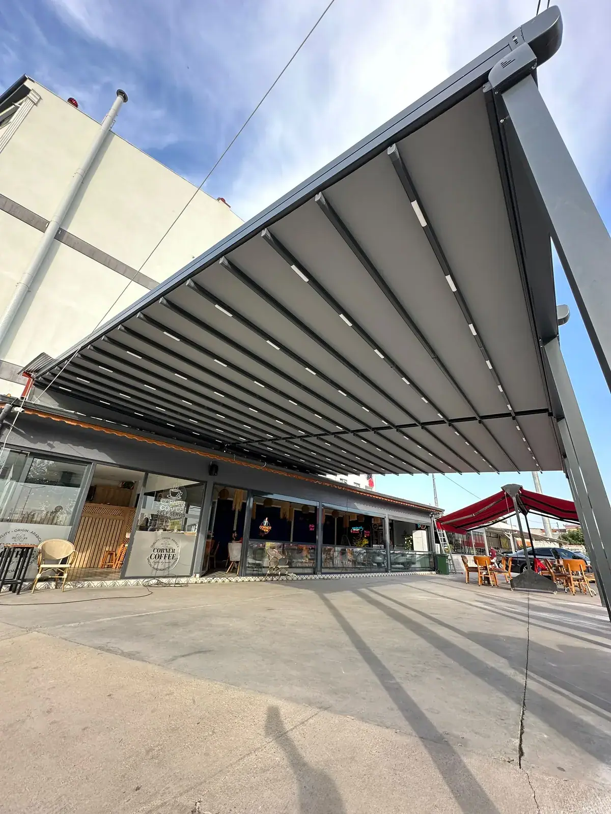 Ticari alanda geniş açıklıklı motorlu pergola tente sistemi